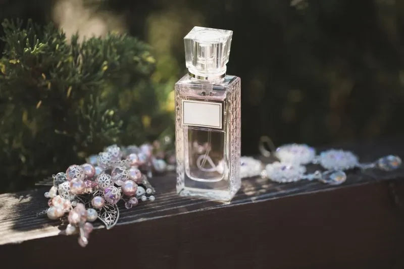 Elegant perfume bottle surrounded by pearls and flowers, illustrating scent combination techniques with floral and sweet notes.