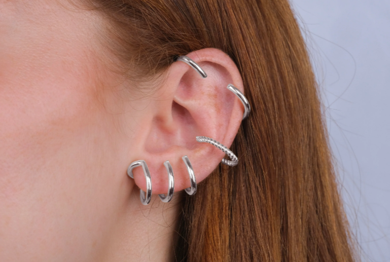 A woman wearing elegant silver earrings, showcasing a stylish and sophisticated accessory choice.