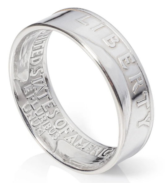 A silver ring engraved with the word "liberty" prominently displayed on its surface.
